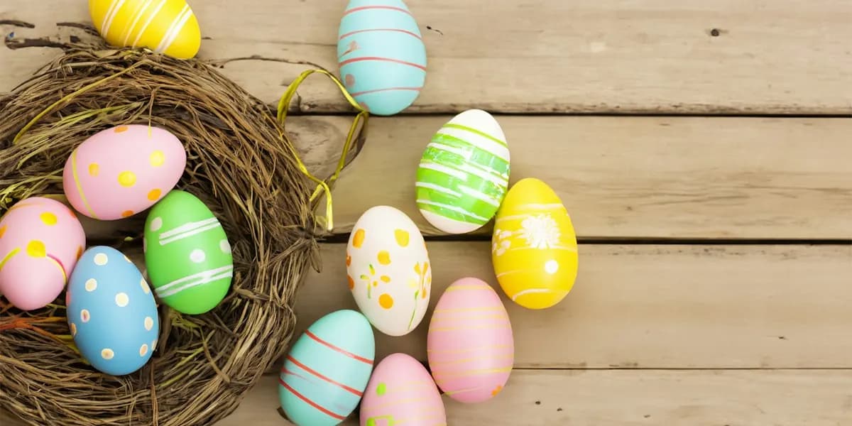 Pastel painted Easter eggs and a nest on a wooden table