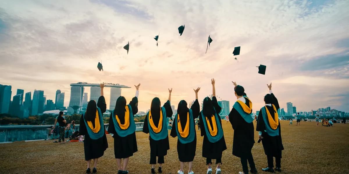 Graduates throwing their caps in the air at sunset