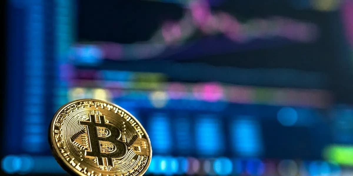 A gold Bitcoin coin in front of a trading chart