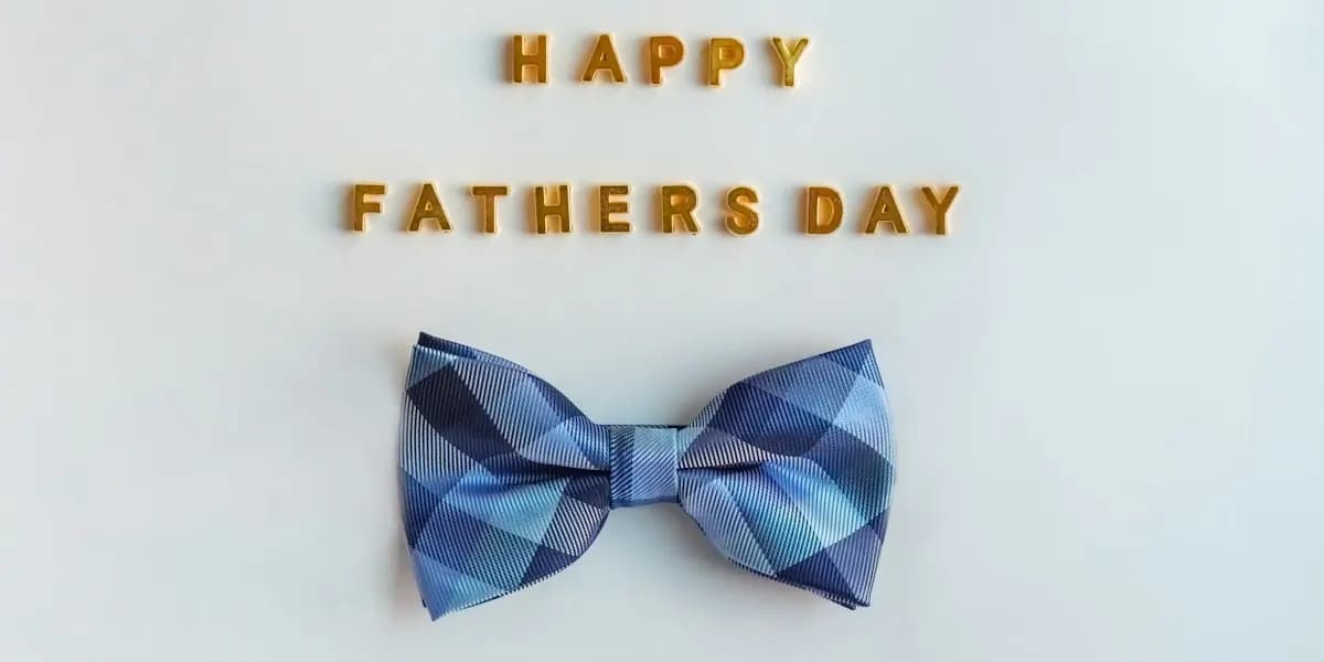 Happy Fathers Day lettering above a blue plaid bow tie